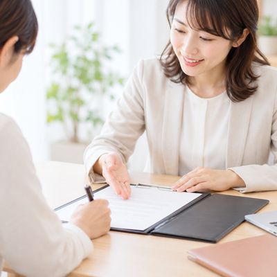 スタッフの説明を受けながら書類にご記入いただく様子